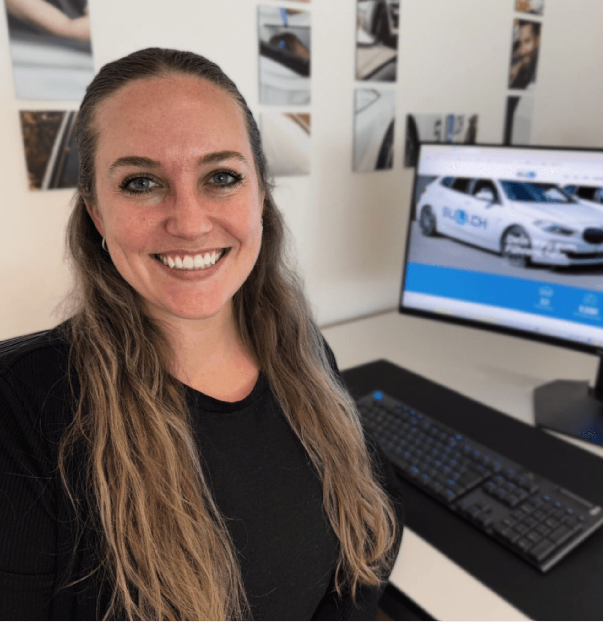 Corinne, Projektleiterin der Fahrschule SULI, lächelt in die Kamera vor dem Logo der Fahrschule.