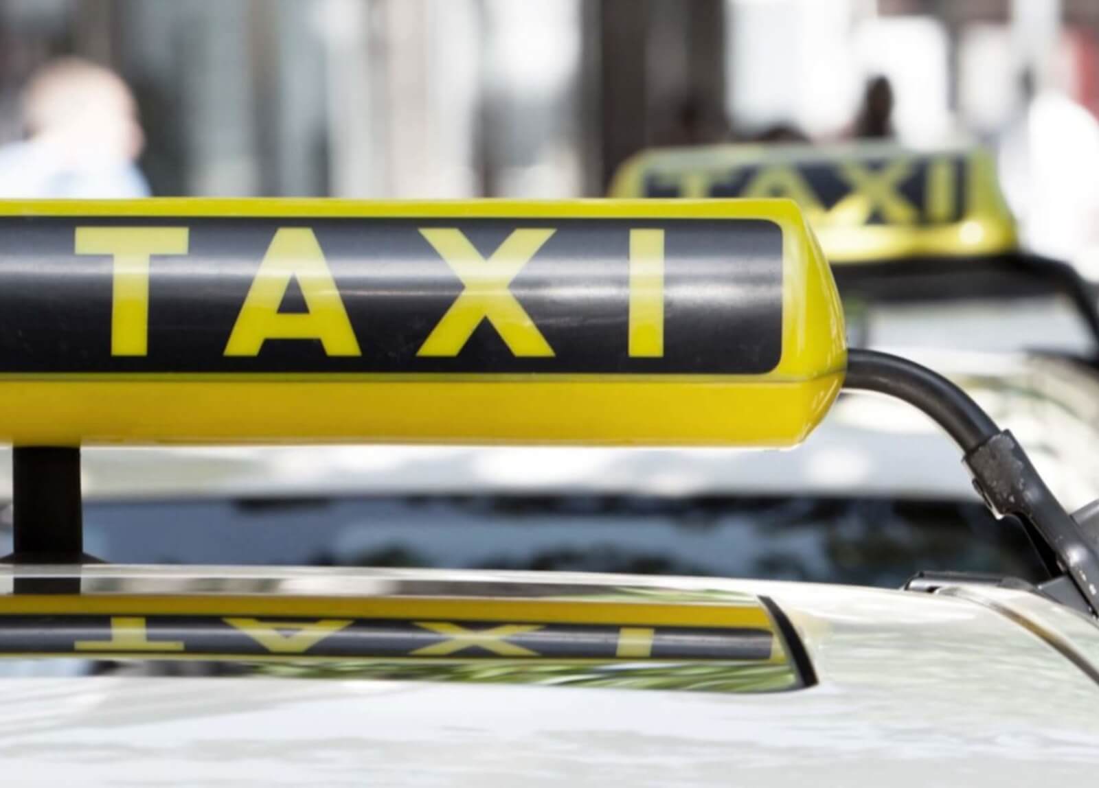 Mehrere Taxi-Schilder auf einem Bild, die symbolisch für die Taxi-Ausbildung und den Einstieg in den Beruf stehen.