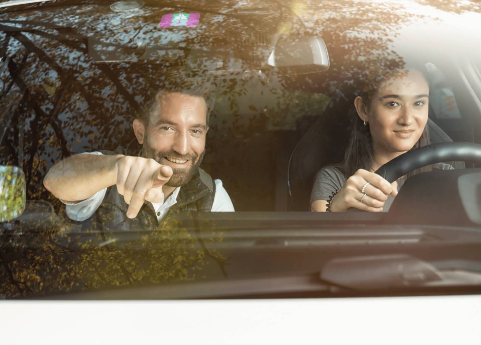 Fahrlehrer und Schülerin im Gespräch während einer Fahrstunde.